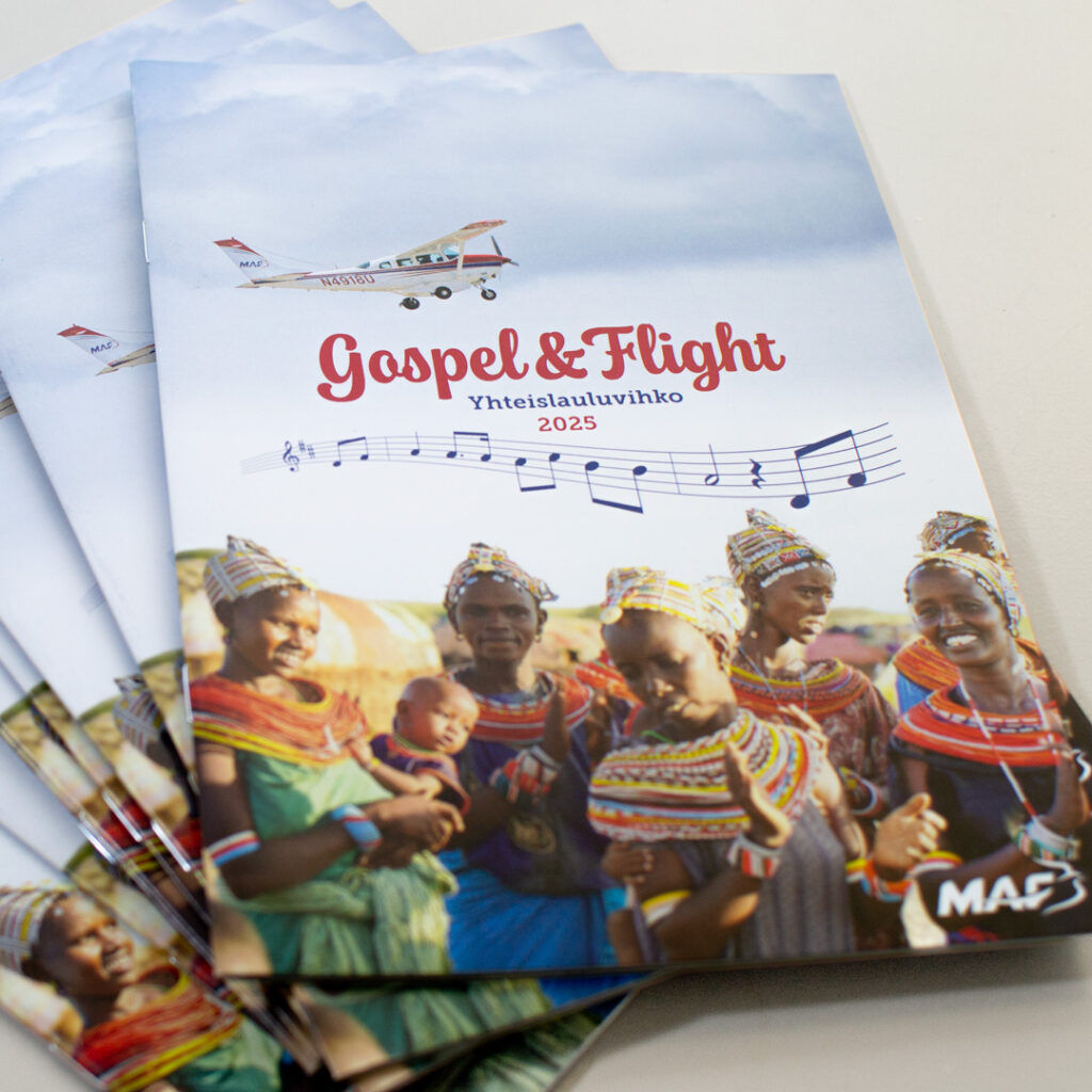 Gospel & Flight -yhteislauluvihko, jonka kansikuvassa iloisia afrikkalaisia naisia ja lentokone