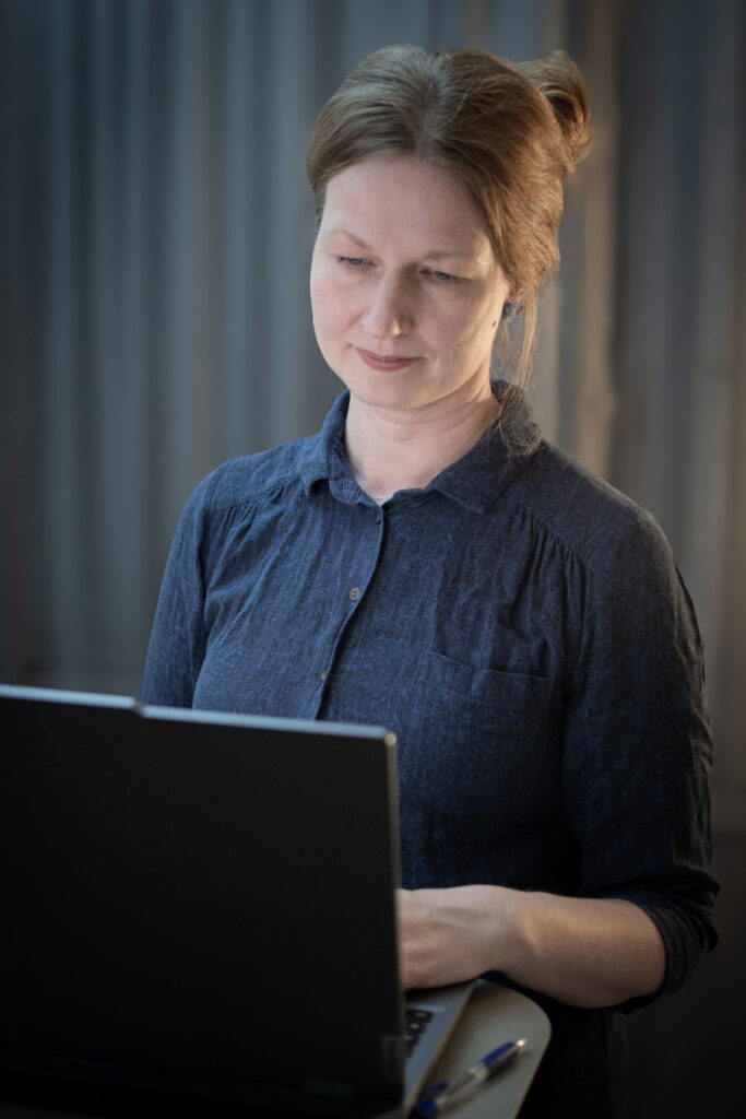 Saara Mansikka-aho katselee keskittyneesti läppärin näyttöä.